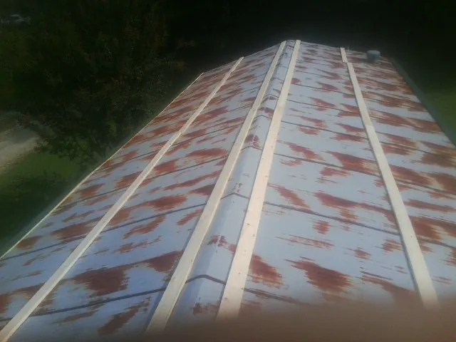 Rusted metal roof panels with new wood purlins before replacement — Storm Damage Roof Repair in Hingham by Roofing Brothers