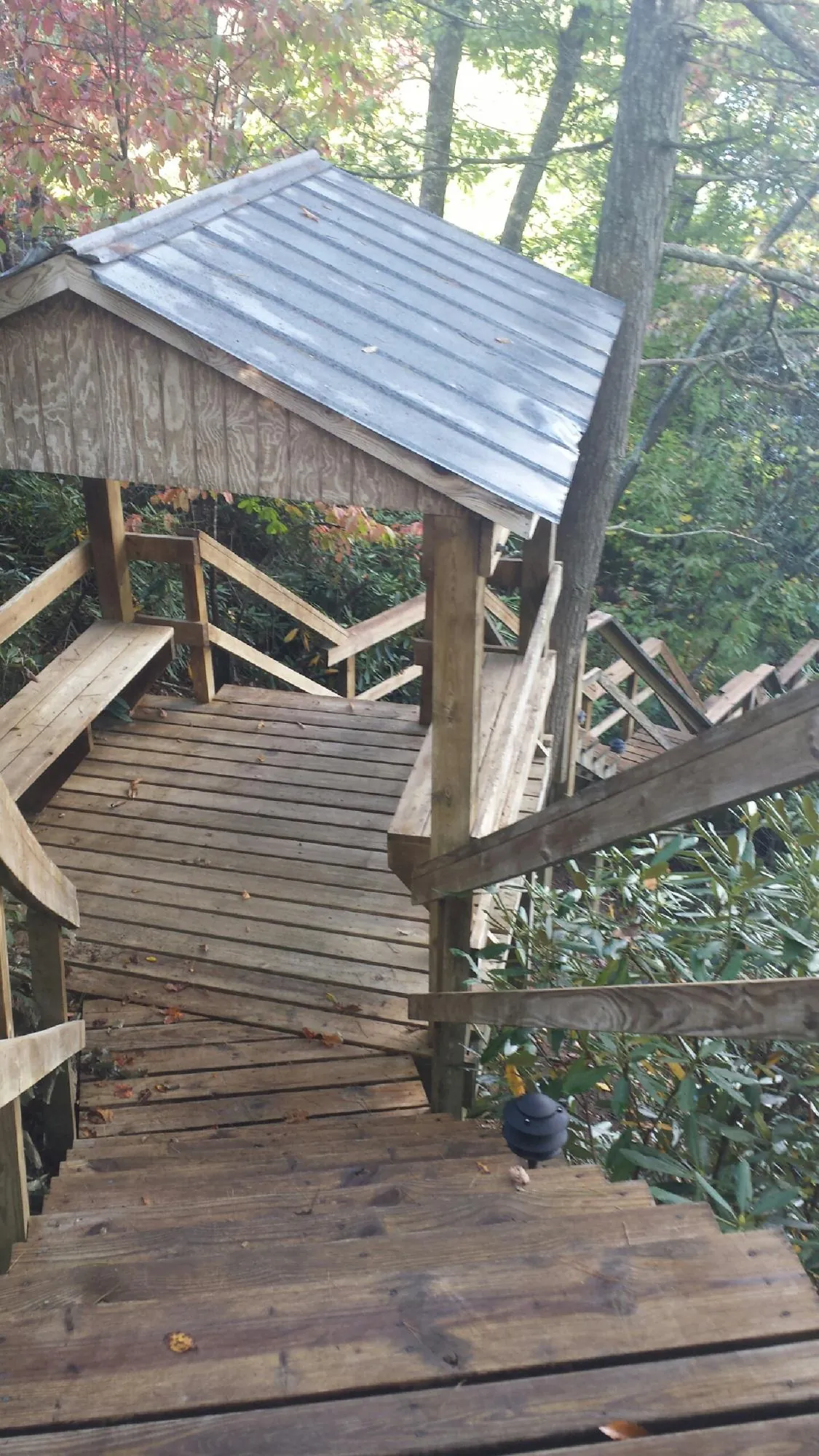 Metal roofed shelter over wooden steps on a wooded walkway — Skylight Repair & Installation work by our crew in Hingham