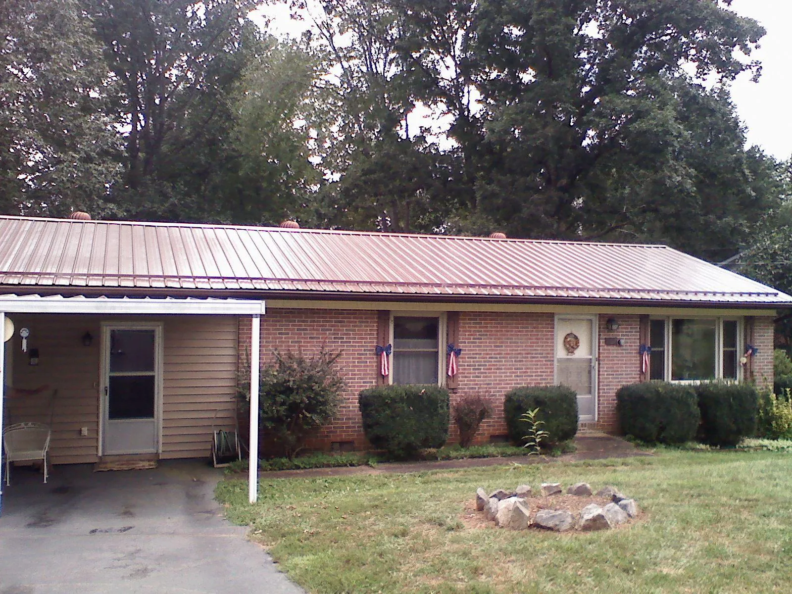 Bronze metal roof and carport on a brick ranch home — Roof Repair work by our crew in Hingham